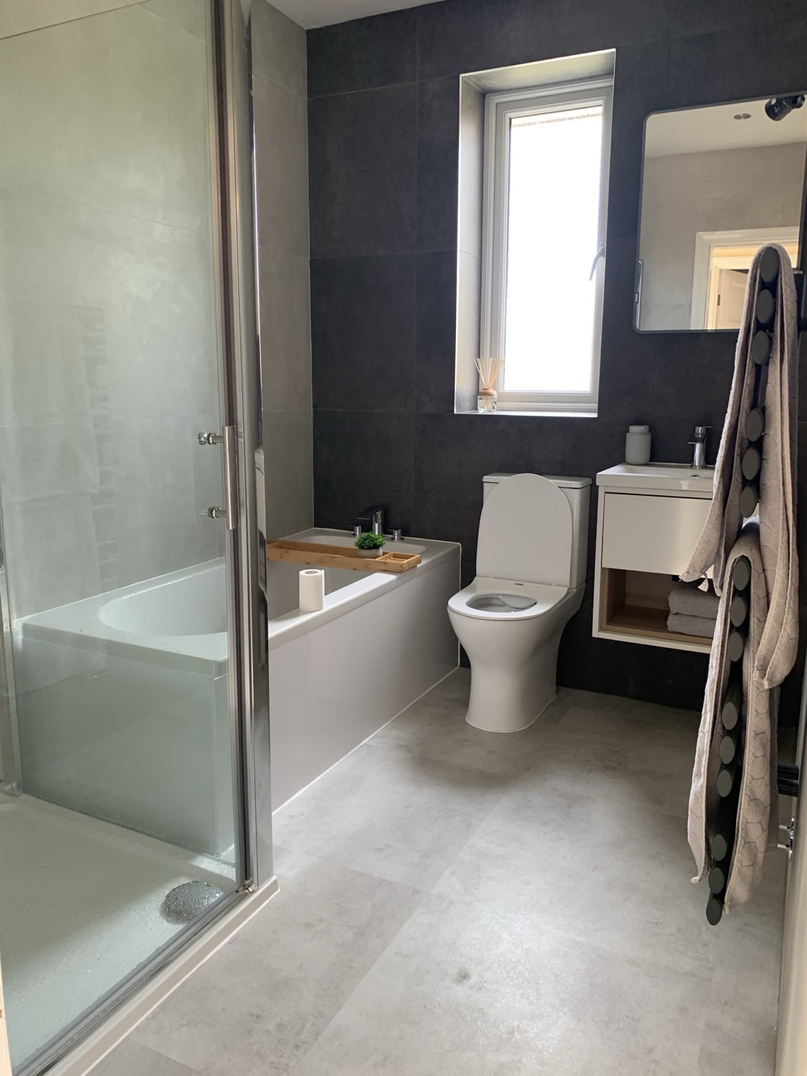 JMB bathroom installation with bath, separate shower enclosure and dark wall tiling